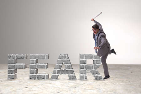 Angry man with baseball bat hitting fear word
