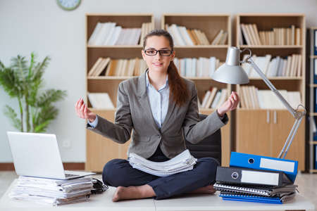 Businesswoman meditating in the officeの写真素材