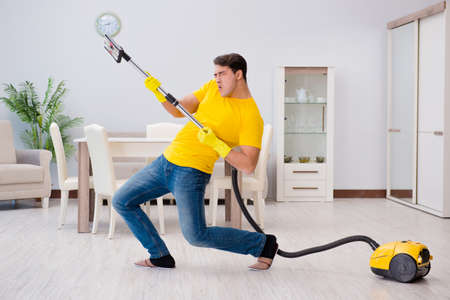 Man playing virtual guitar with vacuum cleanerの写真素材