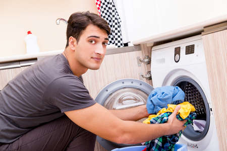 Young husband man doing laundry at homeの写真素材