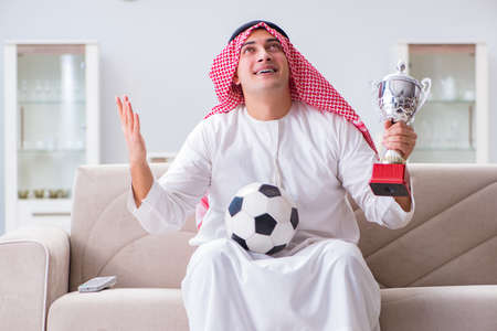 Arab man watching sport football at tvの写真素材