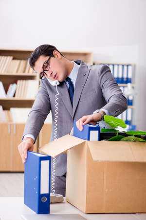 Young businessman moving offices after being made redundantの写真素材