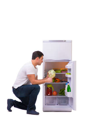 Man next to fridge full of foodの写真素材