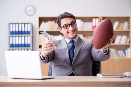 Businessman with american football in officeの写真素材