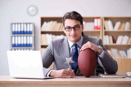 Businessman with american football in officeの写真素材