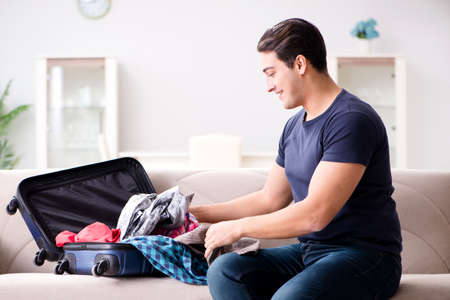 Man going on vacation packing his suitcaseの写真素材