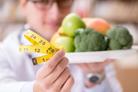 Doctor in dieting concept with fruits and vegetables