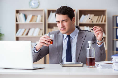 Businessman drinking in the officeの写真素材