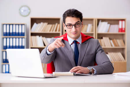 Superhero businessman working in the officeの写真素材