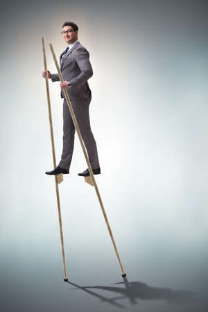 Businessman walking on stilts - standing out from the crowd