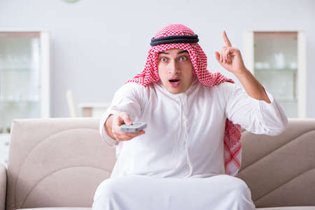 Arab man watching tv at homeの写真素材