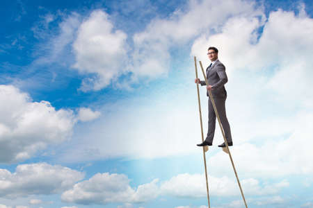 Businessman walking on stilts - standing out from the crowdの写真素材