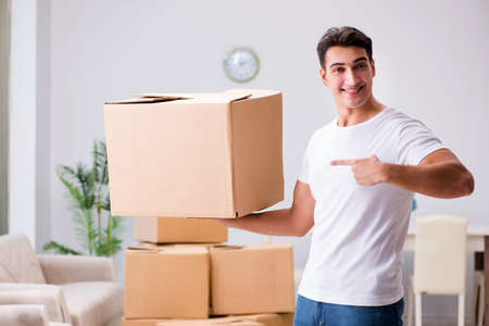 Young man moving boxes at home