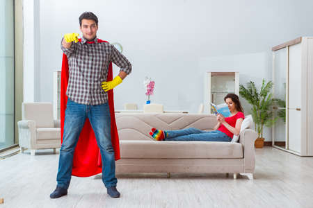 Superhero husband helping his wife at homeの写真素材