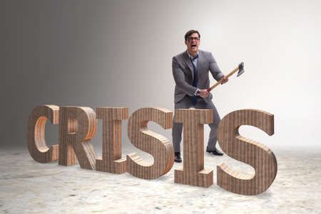 Angry man with axe axing the crisis wordの写真素材