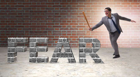 Angry man with baseball bat hitting fear wordの写真素材