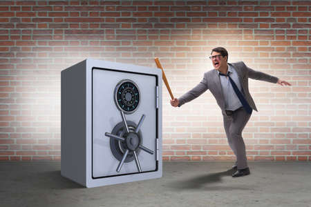 Angry man with baseball bat hitting money safeの写真素材