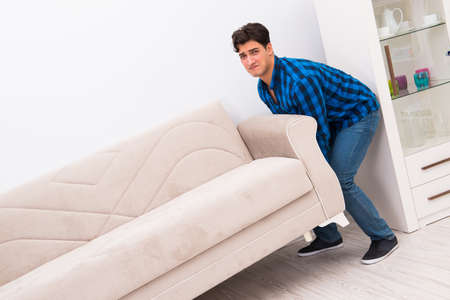 Young man moving sofa couchの写真素材