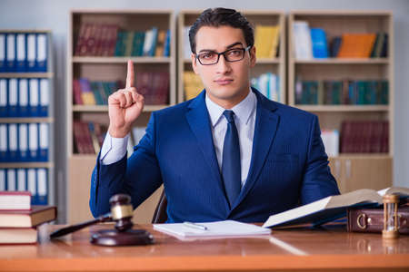 Handsome judge with gavel sitting in courtroomの写真素材