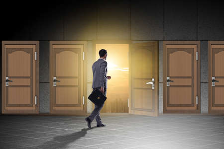 Businessman walking towards open doorの写真素材