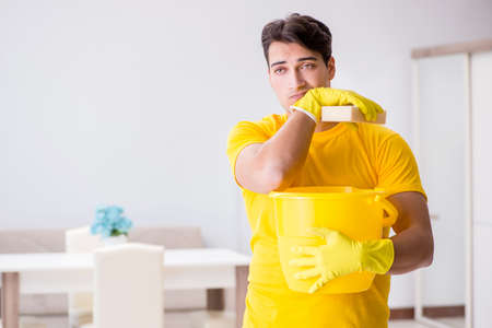 Man husband cleaning the house helping his wifeの写真素材