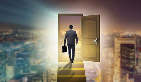 Businessman walking towards open doorの写真素材