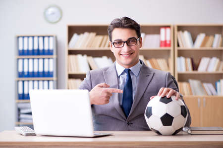 Businessman with football ball in officeの写真素材