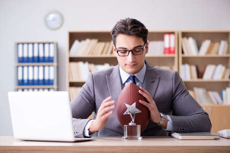 Businessman with american football in officeの写真素材
