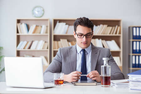 Businessman drinking in the officeの写真素材