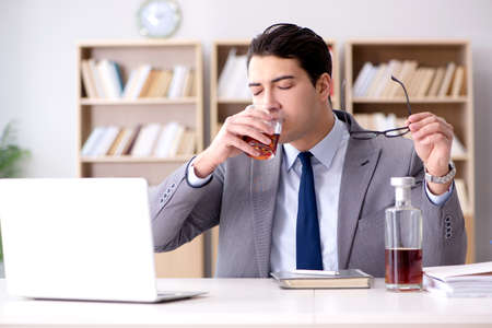 Young businessman drinking from stressの写真素材