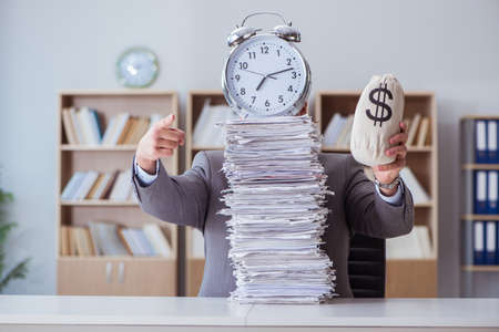 Businessman busy with paperwork in officeの写真素材