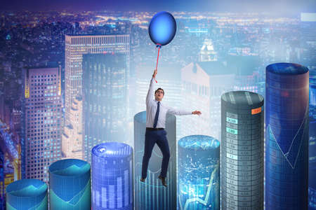 Businessman flying on hot balloon over graphの写真素材