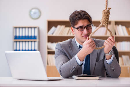 Concept of bankrupt businessman holding onto nooseの写真素材