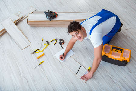Repairman laying laminate flooring at homeの写真素材