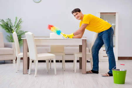 Man cleaning the house helping his wifeの写真素材