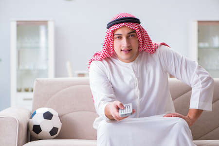 Arab man watching sport football at tv