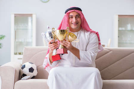 Arab man watching sport football at tvの写真素材