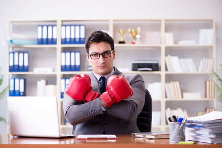 Angry aggressive businessman with boxing glovesの写真素材