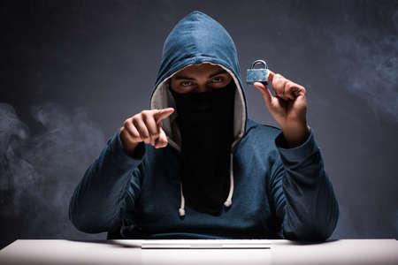 Computer hacker working in dark room