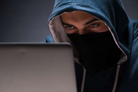 Computer hacker working in dark roomの写真素材