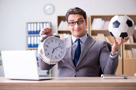 Businessman with football ball in officeの写真素材