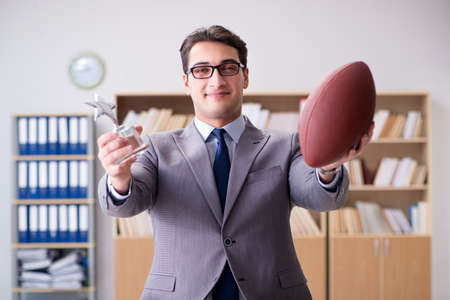 Businessman with american football in officeの写真素材