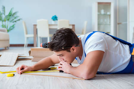 Repairman laying laminate flooring at homeの写真素材