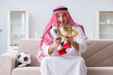 Arab man watching sport football at tvの写真素材