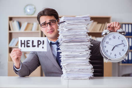 Businessman busy with paperwork in officeの写真素材