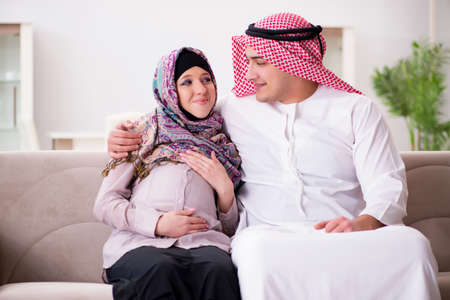 Young arab muslim family with pregnant wife expecting babyの写真素材