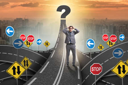 Businessman in uncertainty concept on road intersection crossroaの写真素材