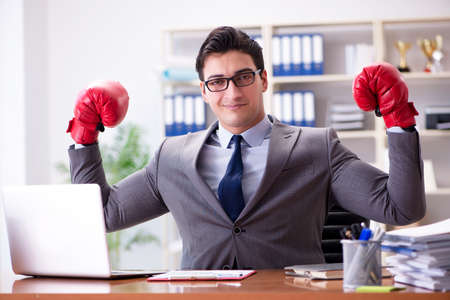 Angry aggressive businessman with boxing glovesの写真素材
