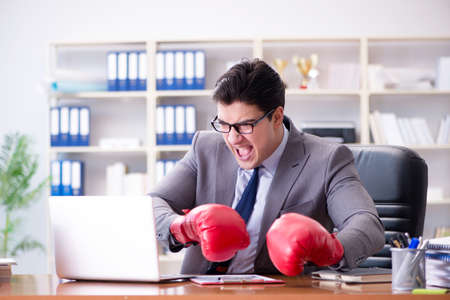 Angry aggressive businessman with boxing glovesの写真素材