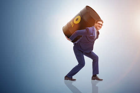 Businessman under the burden of oil barrel